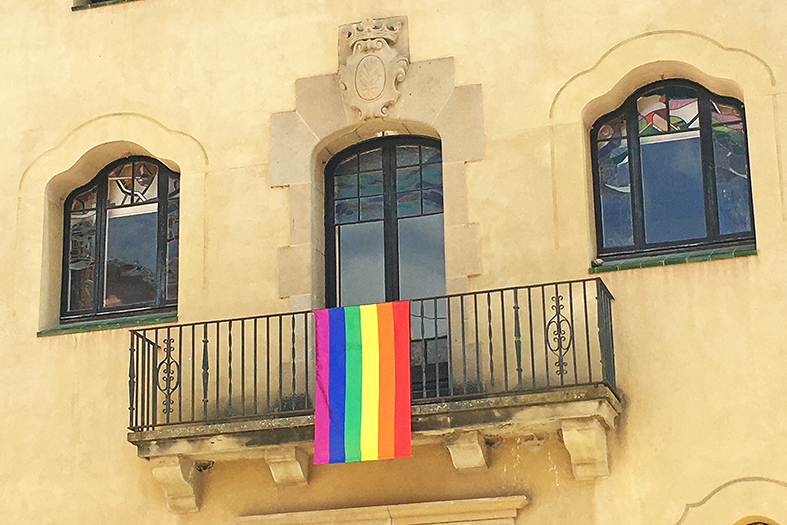 La bandera del col·lectiu LGBTI, a la façana principal de la Casa de la Vila com a mostra d'adhesió institucional amb el Dia Internacional contra la LGBTIfòbia.