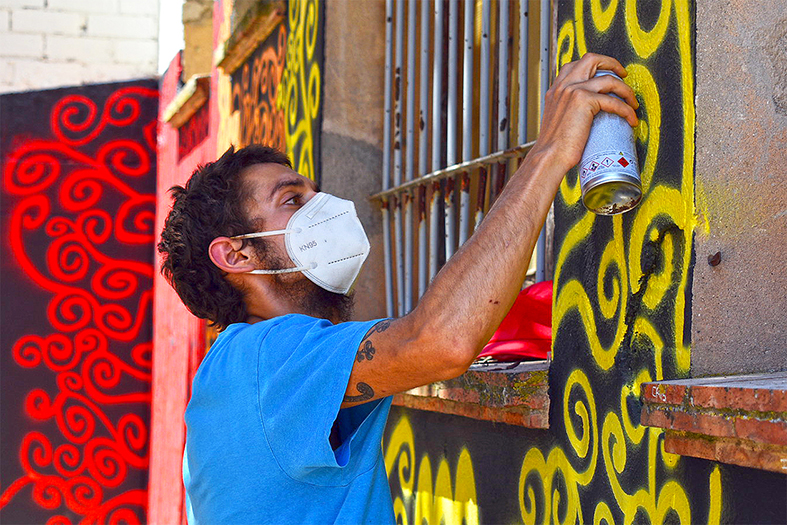 L'artista surienc David Macià, durant la realització del mural commemoratiu del Dia Internacional de l'Orgull LGBTI a l'entorn de les Pistes de l'Escorxador de Súria, dins del projecte comarcal +ART.