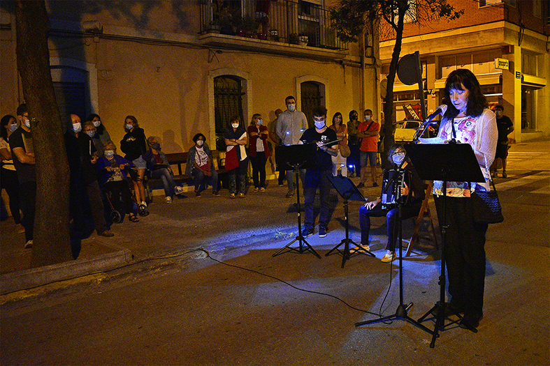 La bibliotecària de Súria, Maria Àngels Alsina, parla a les persones participants en el passeig literari del 70è aniversari de la Biblioteca Pública, a l'avinguda de l'Ajuntament.