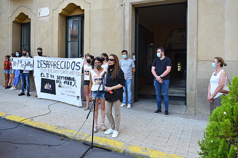 La regidora de Benestar Social, Olga Tena (dreta) parla a les persones concentrades al davant de la Casa de la Vila en l'acte de record del 33è aniversari de la desaparició dels germans Pires Òrrit, al costat d'una representant de la família.