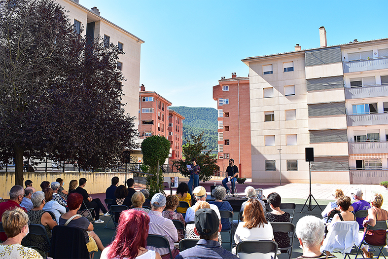 Imatge de la lectura poètica sobre Joan Margarit a la plaça interior del Grup Sant Sebastià, amb Josep Maria Rodríguez i Estel Solé.