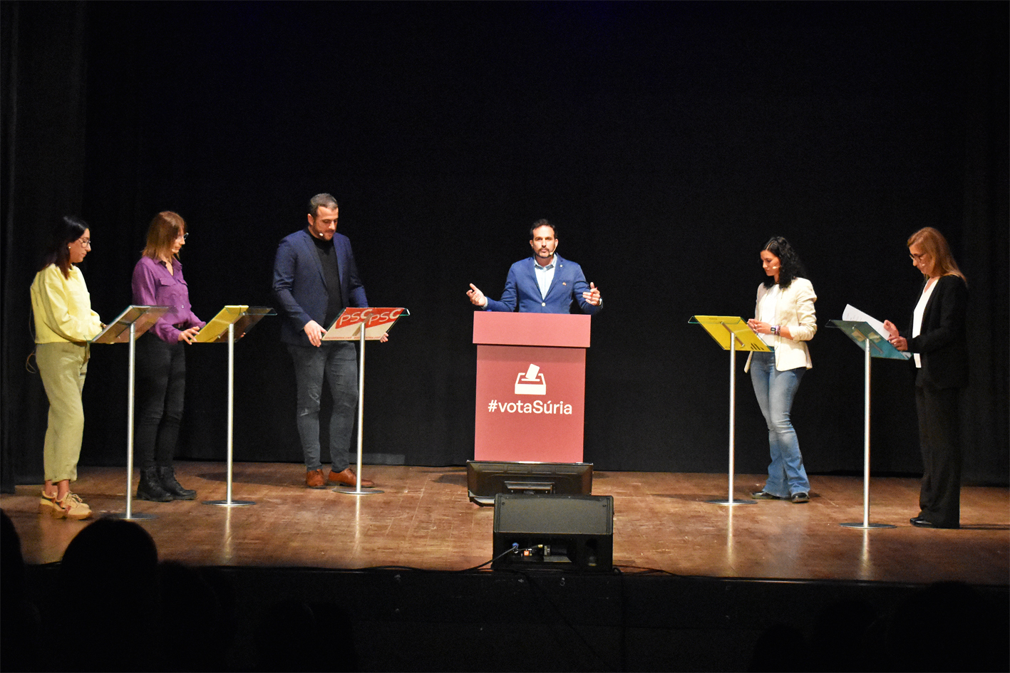 Caps de les cinc candidatures i el periodista surienc Francesc Garriga, durant el debat electoral organitzat per Ràdio Súria i El Salí al Teatre del Foment Cultural.