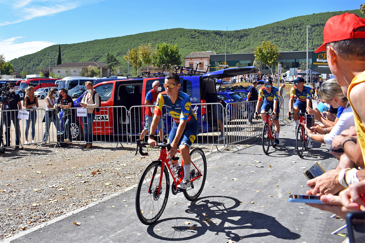 Diferents ciclistes s'adrecen al punt de control de signatures de la tercera etapa de La Vuelta 2023, al Rieral del Tordell.