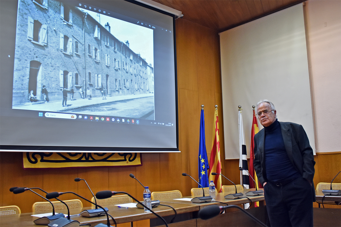 El ponent Demetri Domínguez, al costat d'una foto històrica de la Colònia, actual barri Santa Maria, durant l'acte d'obertura de la Festa de Santa Bàrbara.