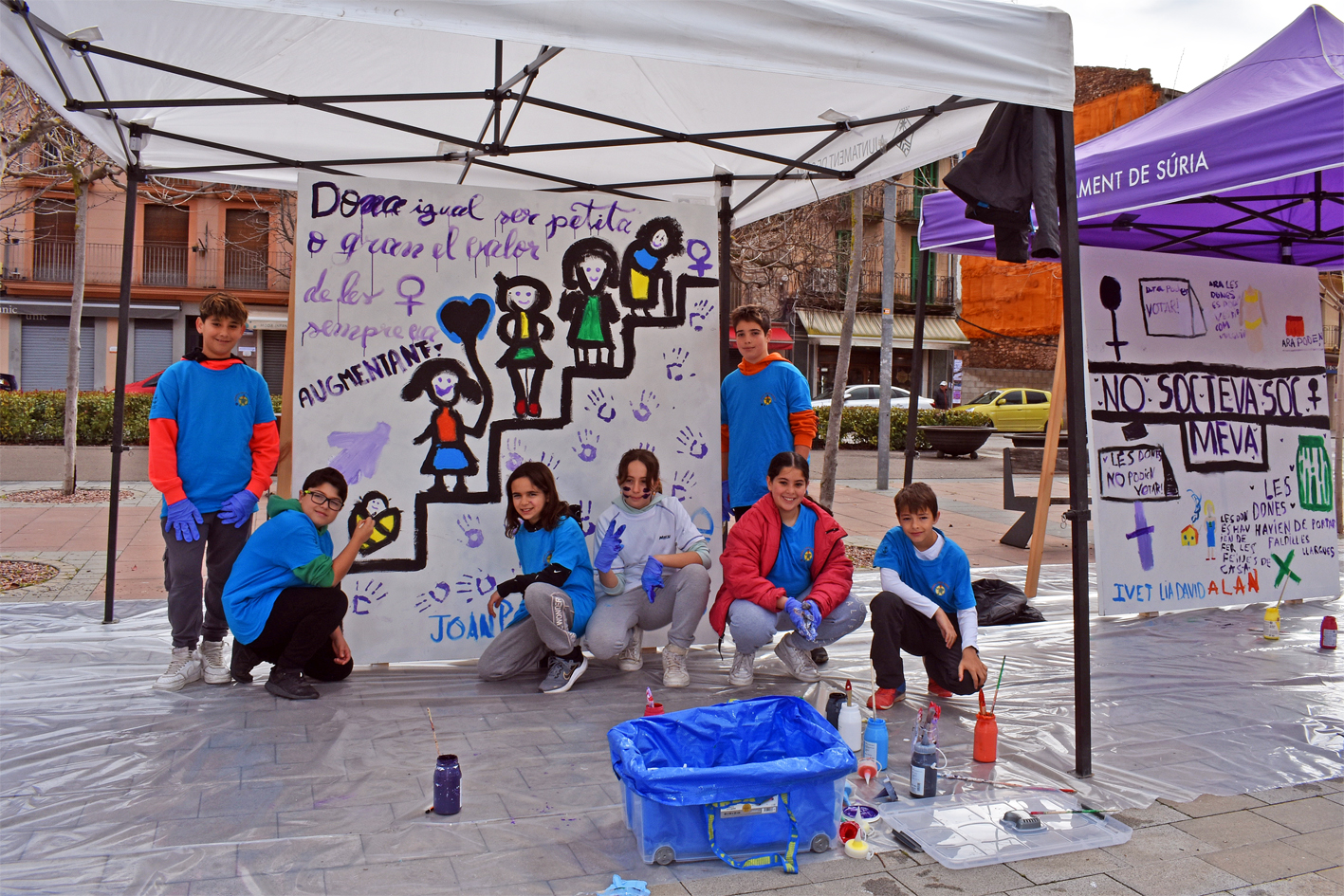 Curs 2023-24 - Membres del Consell Municipal dels Infants, davant de dos dels murals pintats a la plaÃ§a de Sant Joan, dins del programa del Dia Internacional de la Dona.
