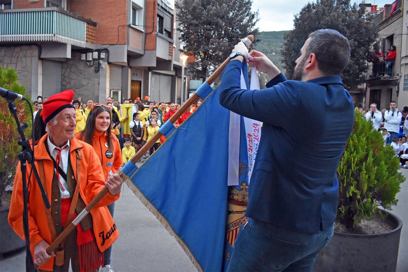 Lliurament de la cinta commemorativa de les Caramelles de SÃºria 2024 a la colla del Tro Gros, en lâ€™acte dâ€™inici de la festa al davant de la Casa de la Vila.