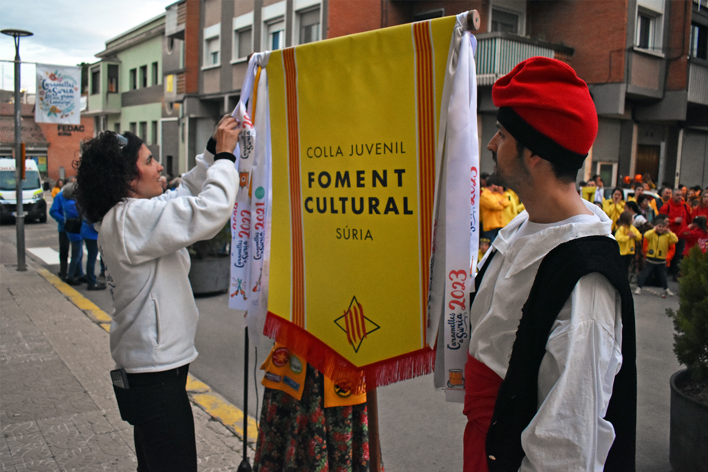 Lliurament de la cinta commemorativa de les Caramelles de SÃºria 2024 a la colla Juvenil del Foment Cultural, en lâ€™acte dâ€™inici de la festa al davant de la Casa de la Vila.