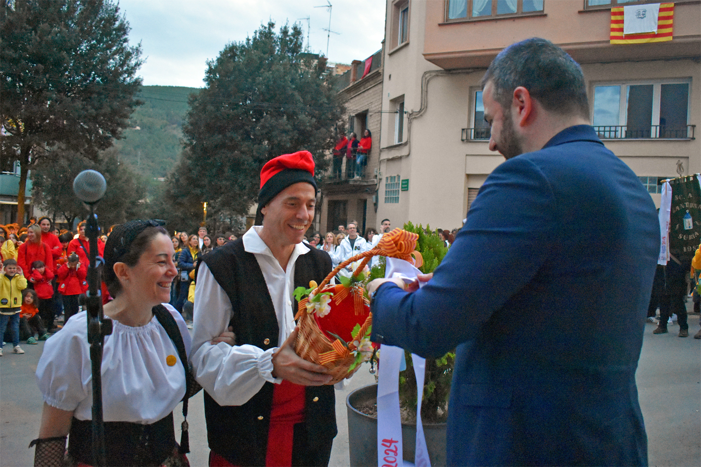 Lliurament de la cinta commemorativa de les Caramelles de SÃºria 2024 a la colla Gran del Foment Cultural, en lâ€™acte dâ€™inici de la festa al davant de la Casa de la Vila.