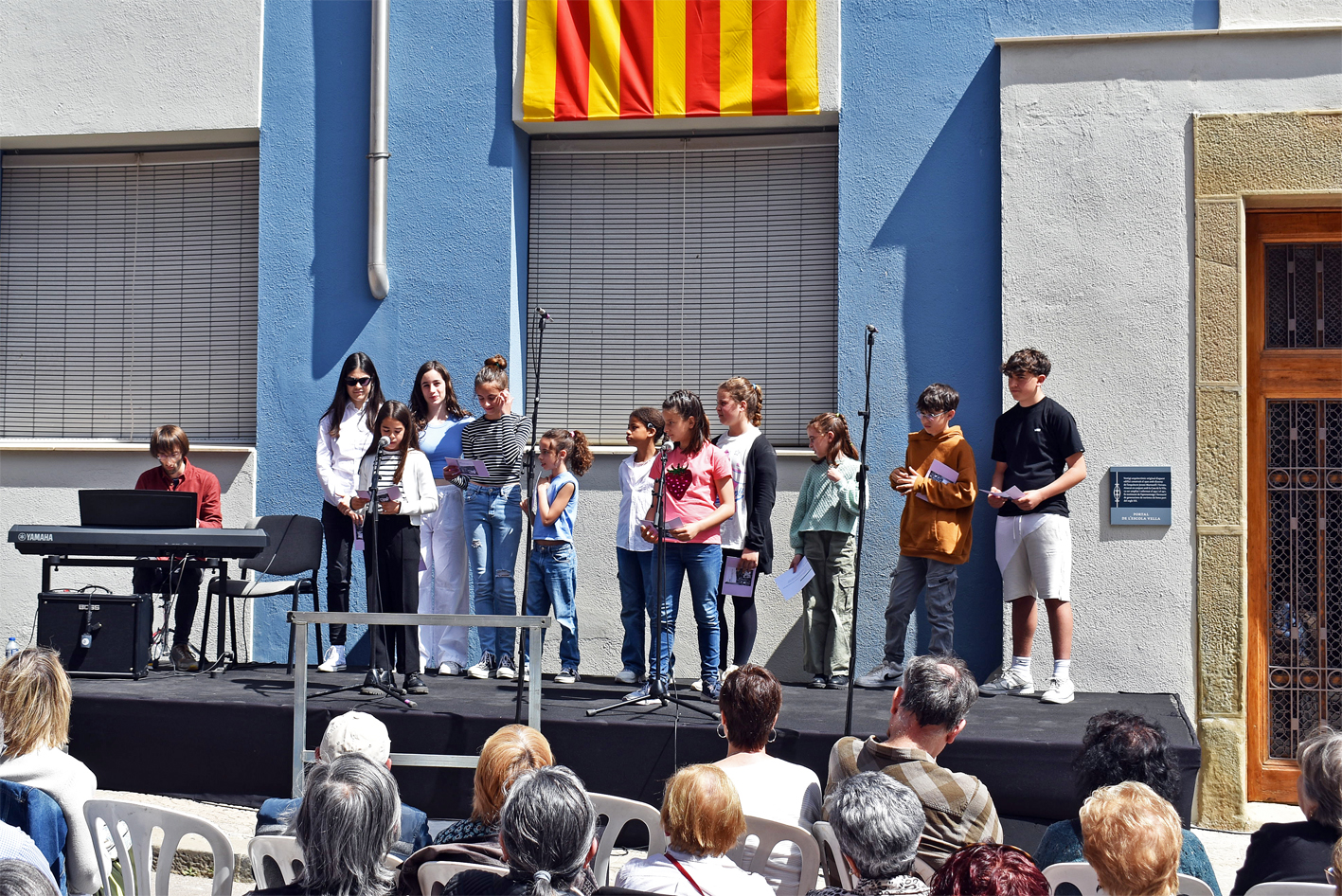 Lectura de textos del llibre 'Albor. La veu dels nens i nenes de Súria en el temps de la guerra' de Magda Esquius, durant l'acte de presentació al davant de l'edifici de l'Escola Vella, dins del cicle 'Per Sant Jordi, llibres de casa'.