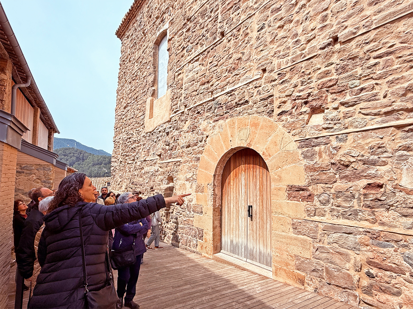 L'arquitecta Clàudia Sanmartí assenyala una de les façanes restaurades del Castell, durant la visita guiada posterior a la xerrada 'Noves visions prop del Castell de Súria'.