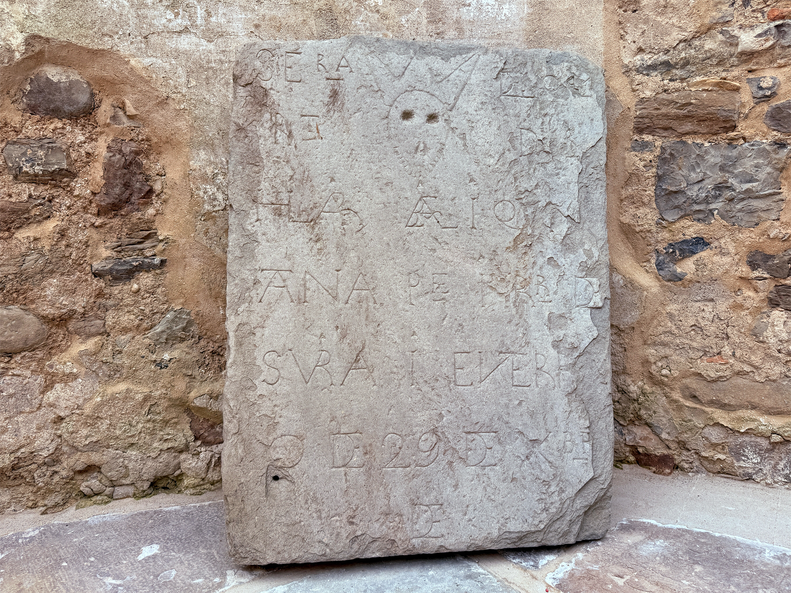 Làpida funerària del segle XVIII, en l'espai del sobreabsis de l'Església del Roser.