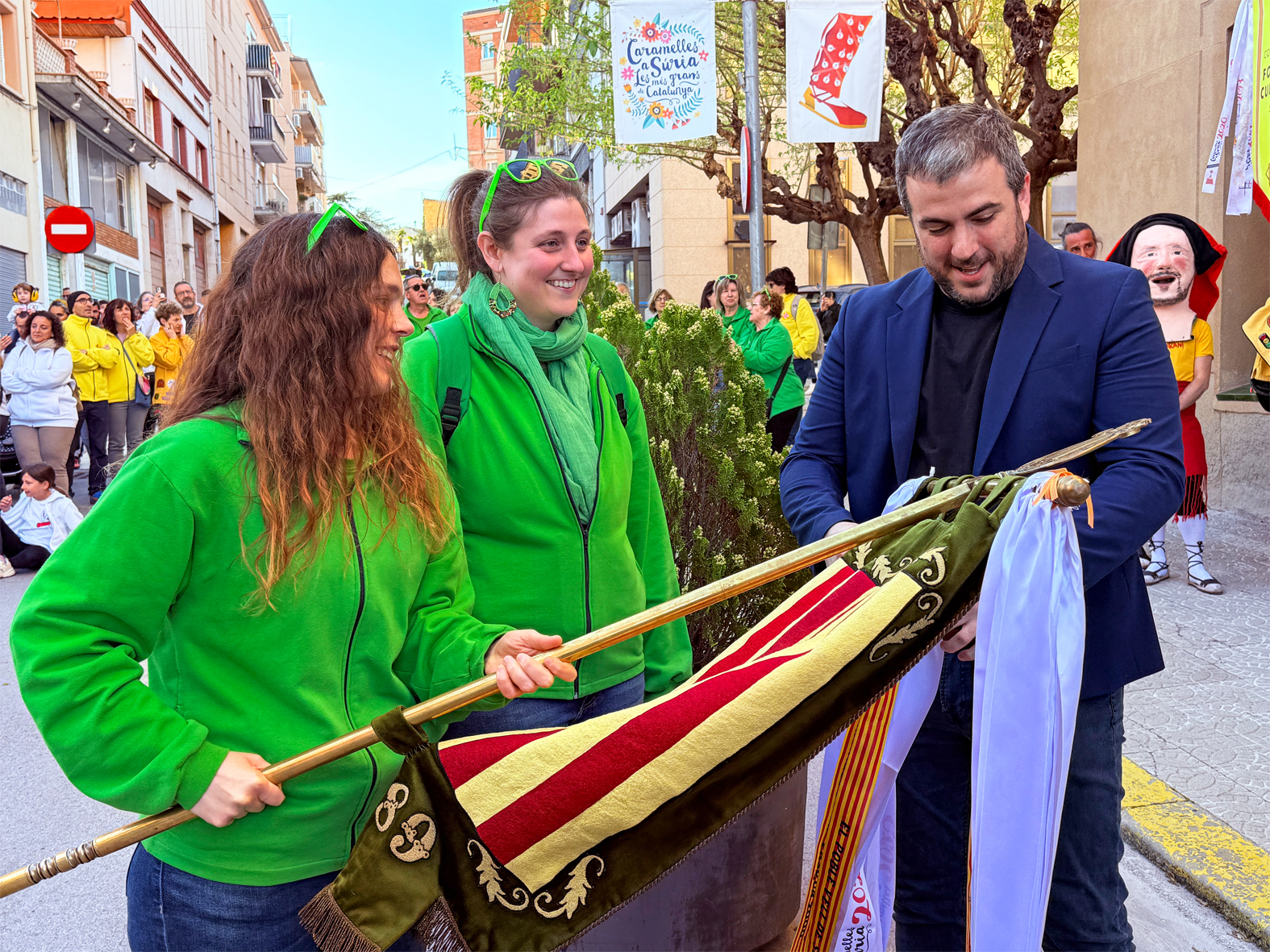 L'alcalde Albert CoberÃ³ lliura la cinta commemorativa a la colla de La Llanterna, en l'acte d'inici de les Caramelles de SÃºria, al davant de la Casa de la Vila.