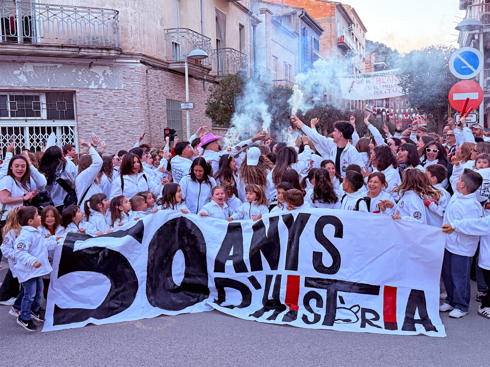 Les colles de l'AgrupaciÃ³ Sardanista durant la Passada Caramellaire amb una pancarta sobre el 50Ã¨ aniversari dels Bastoners, en l'inici de les Caramelles de SÃºria.