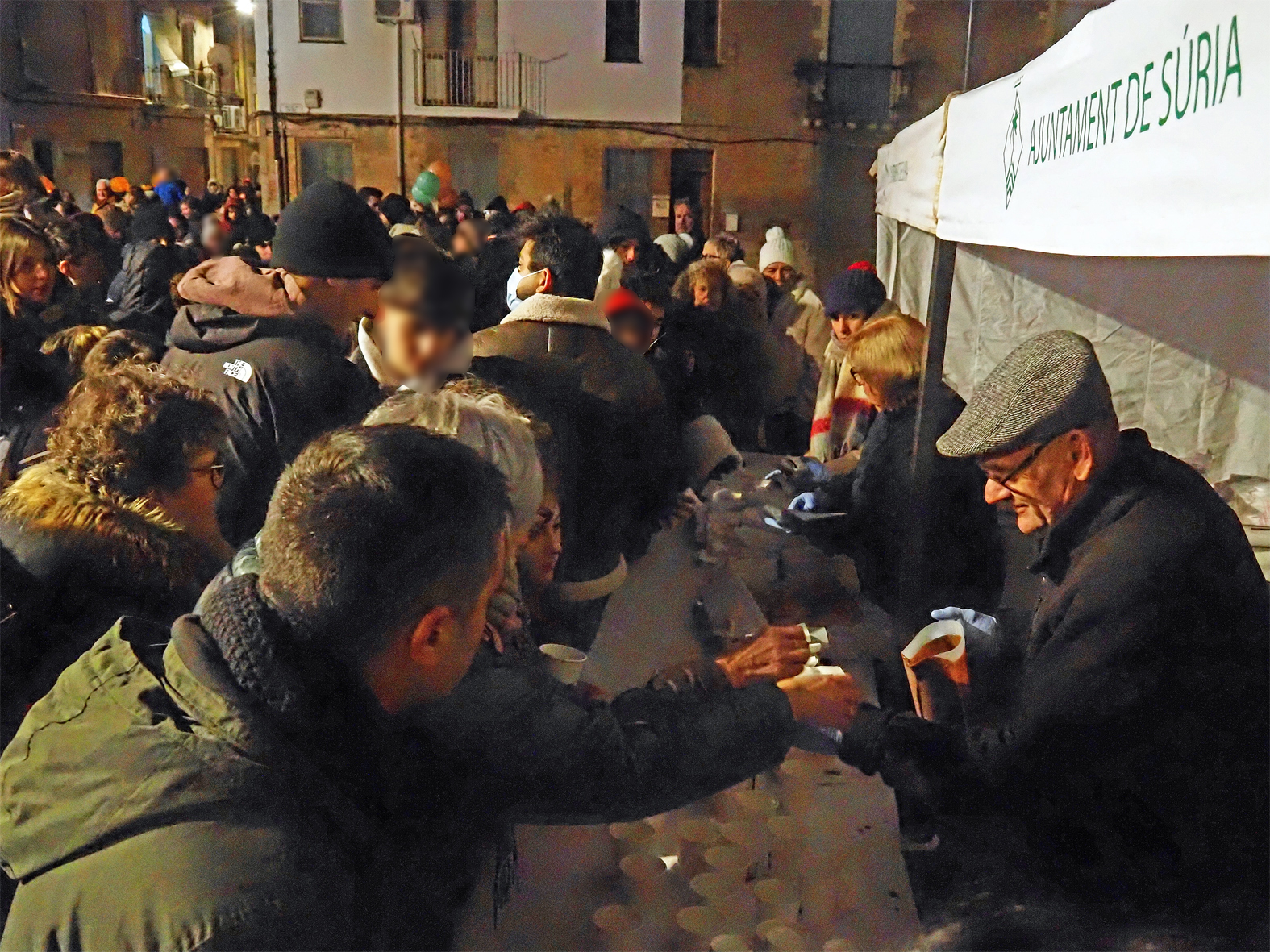 Repartiment de coca i xocolata a l'entorn de l'Esgl&eacute;sia Parroquial de Sant Crist&ograve;fol, dins de la Cavalcada de Reis a S&uacute;ria.
