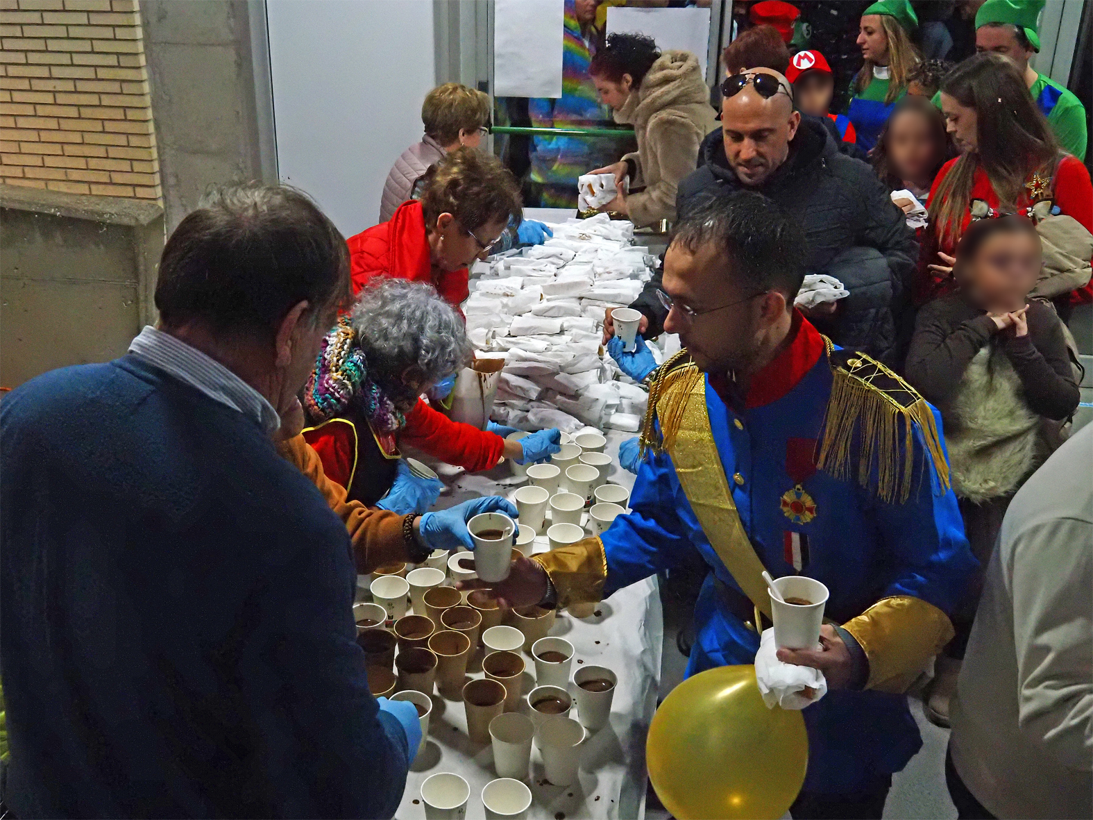 Repartiment de coca i xocolata a les persones participants en la rua del Carnestoltes de SÃºria.