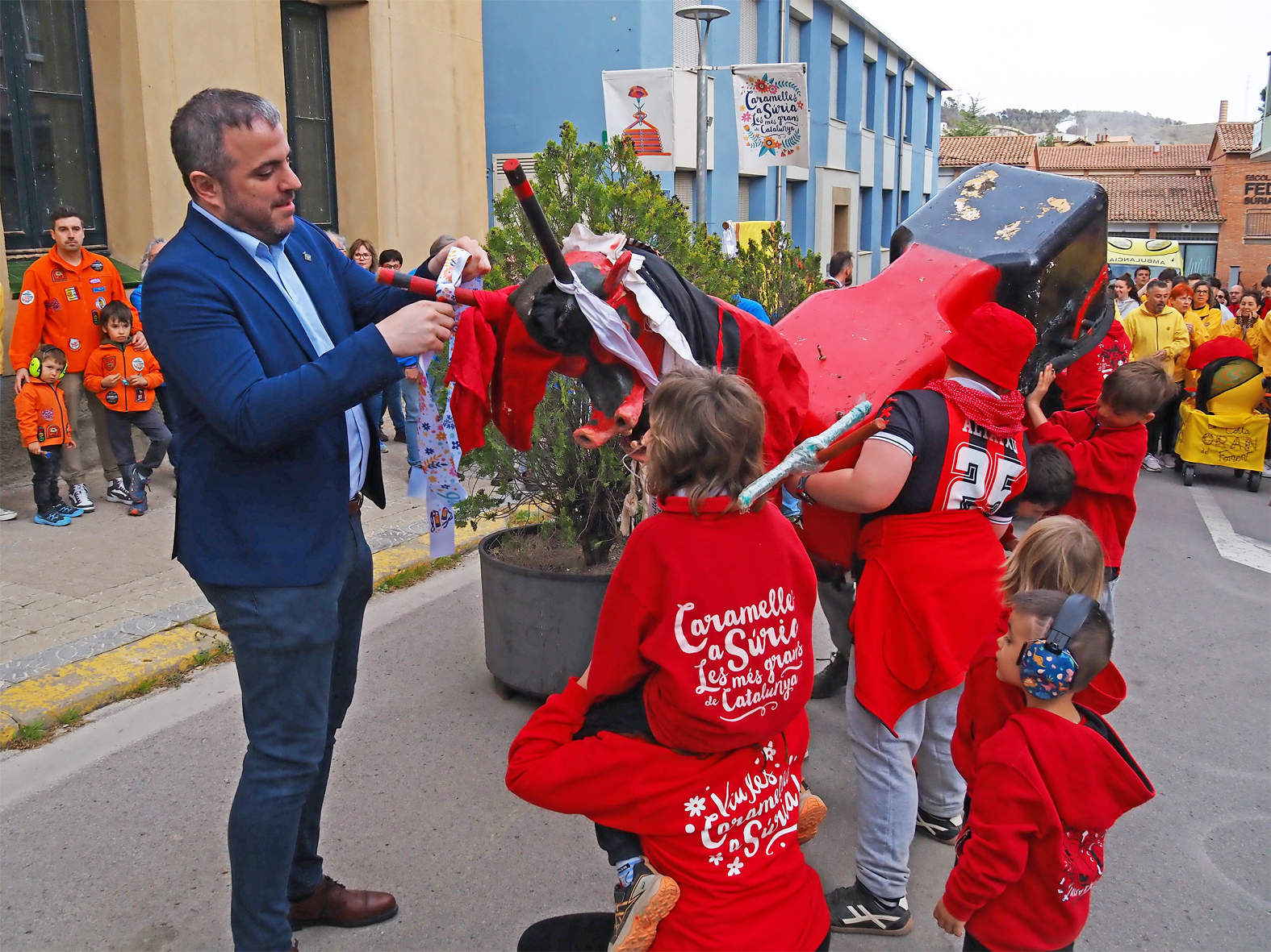 L'alcalde Albert Cober&oacute; lliura la cinta commemorativa a la colla d'Altatxets en l'acte d'inici de les Caramelles de S&uacute;ria, al davant de la Casa de la Vila.