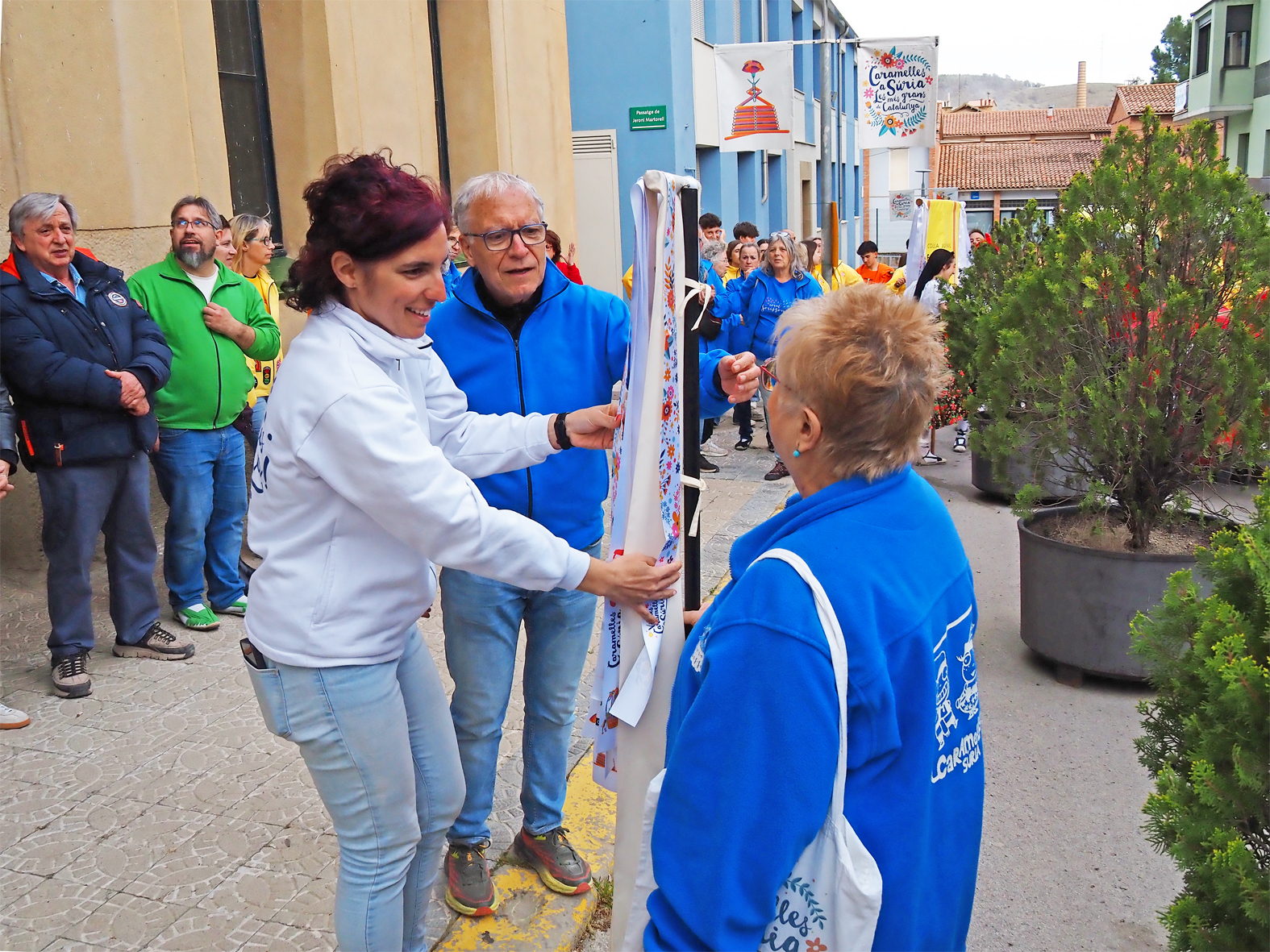 La regidora de Festes, Alba MartÃ­nez lliura la cinta commemorativa a la colla de la Coral SÃ²rissons en l'acte d'inici de les Caramelles de SÃºria, al davant de la Casa de la Vila.