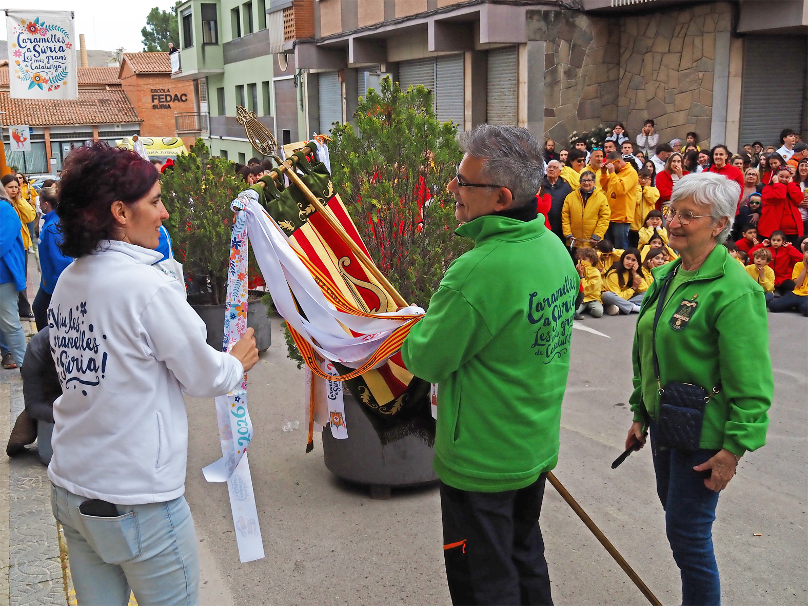 La regidora de Festes, Alba MartÃ­nez lliura la cinta commemorativa a la colla de La Llanterna en l'acte d'inici de les Caramelles de SÃºria, al davant de la Casa de la Vila.