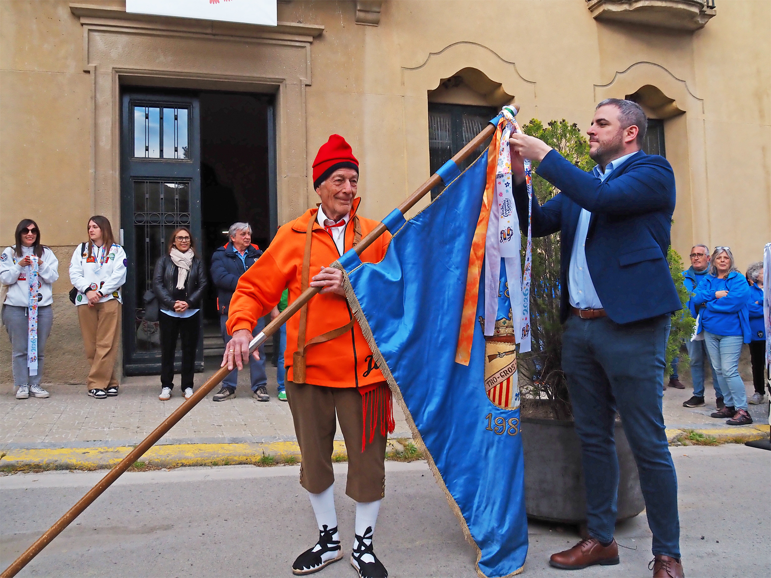 L'alcalde Albert CoberÃ³ lliura la cinta commemorativa a la colla del Tro Gros en l'acte d'inici de les Caramelles de SÃºria, al davant de la Casa de la Vila.