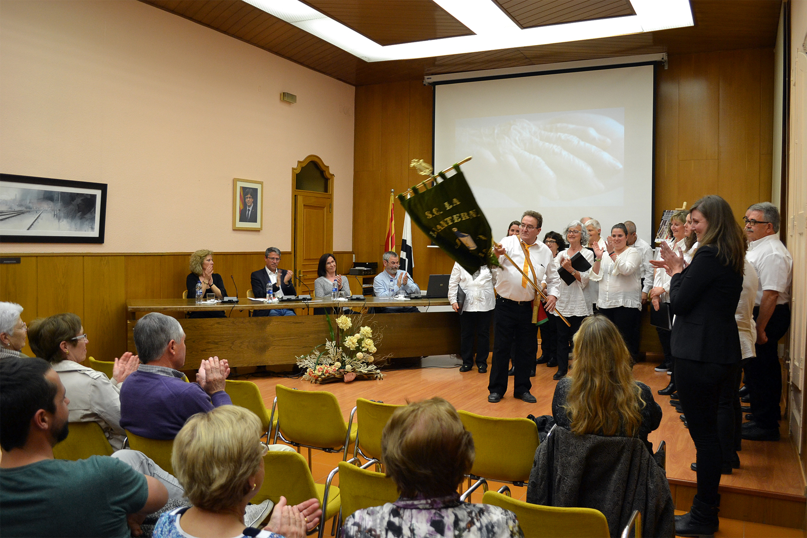 Tradicional salutaciÃ³ de l'estendard de la Societat Coral La Llanterna desprÃ©s de la seva actuaciÃ³ durant l'acte de presentaciÃ³ dels nous cartells de la campanya 'Tracta'm bÃ©' amb imatges de les Caramelles de SÃºria - Abril de 2017.