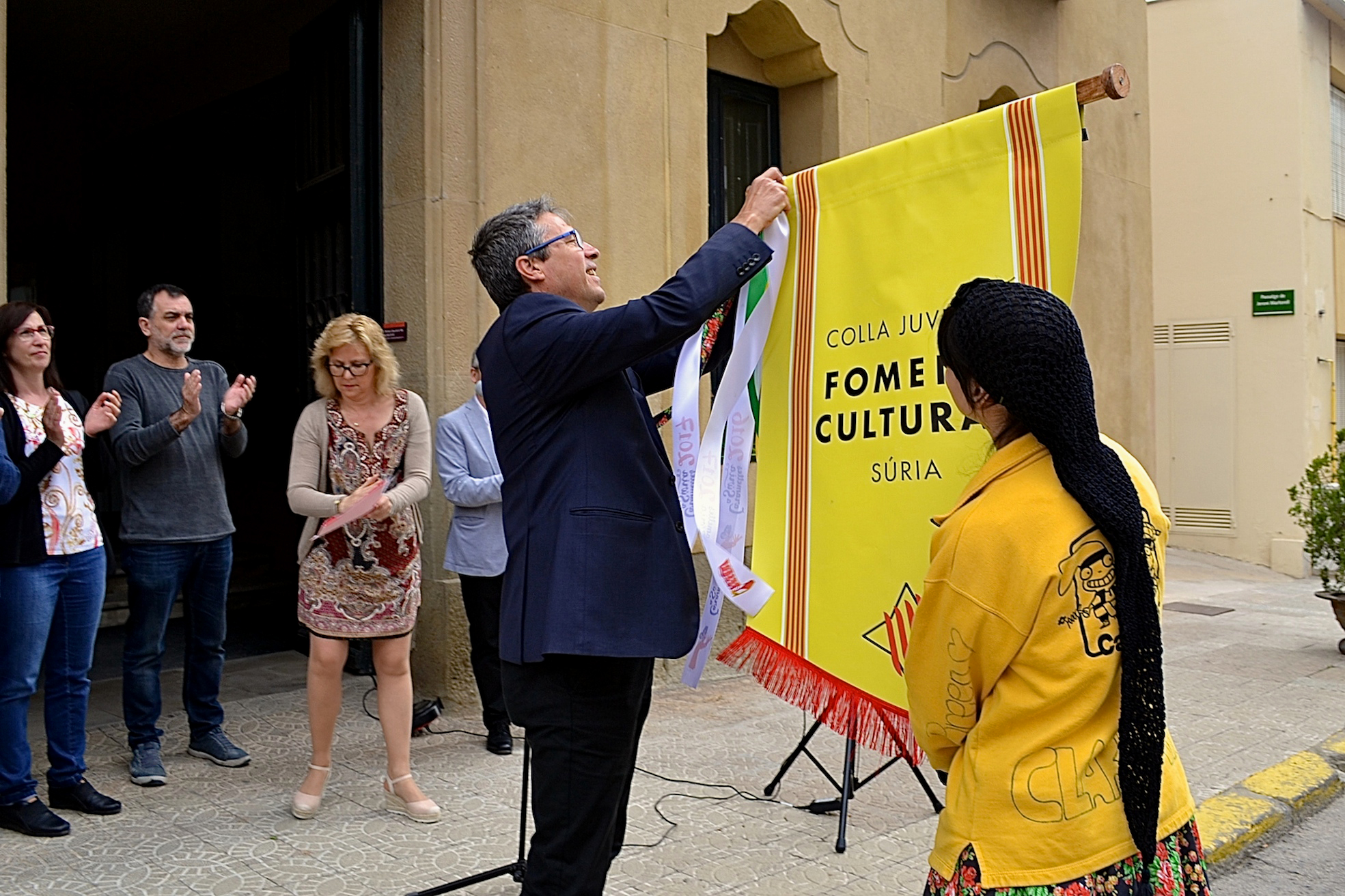 L'alcalde Josep Maria Canudas colâ€¢loca la cinta commemorativa de les Caramelles de SÃºria 2017 en l'estendard de la colla Juvenil del Foment Cultural - Abril de 2017.