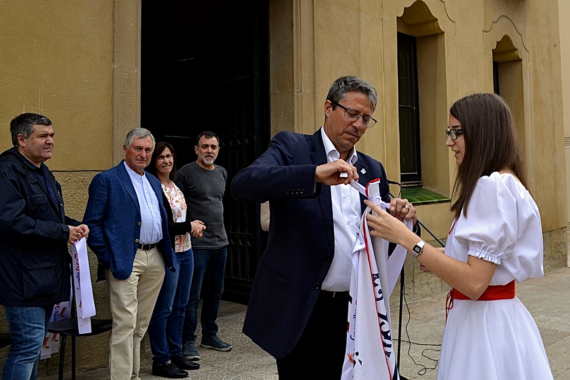 L'alcalde Josep Maria Canudas colâ€¢loca la cinta commemorativa de les Caramelles de SÃºria 2017 en l'estendard de la colla dels Grans de l'AgrupaciÃ³ Sardanista - Abril de 2017.