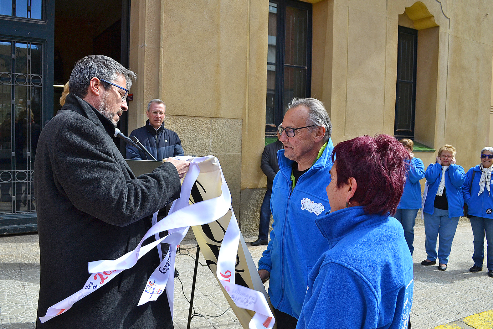 L'alcalde Josep Maria Canudas posa la cinta de les Caramelles de SÃºria 2018 a l'estendard de la colla de la Coral SÃ²rissons - MarÃ§ de 2018.