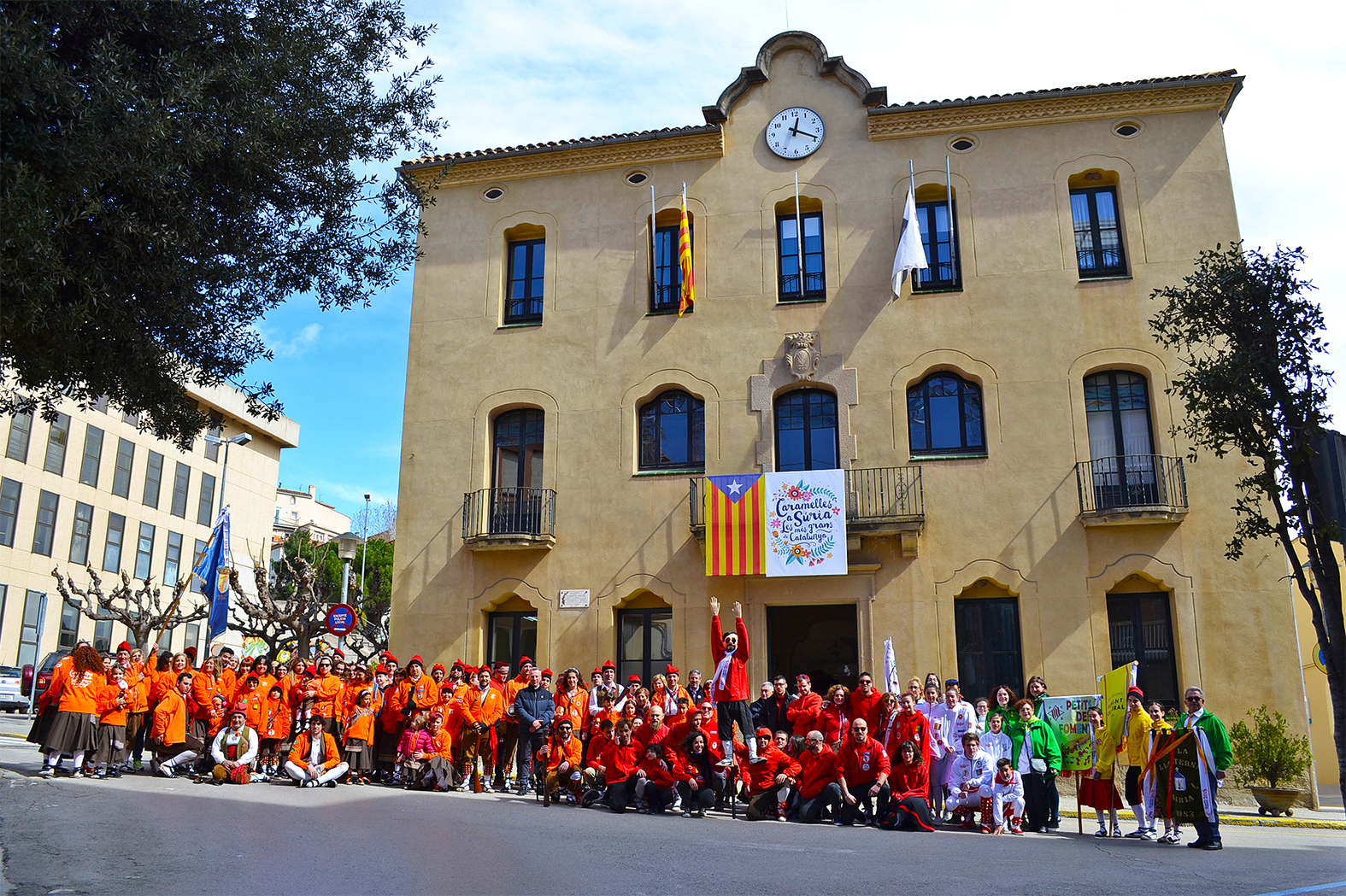 Foto de grup dels caramellaires i dels representants institucionals participants en l'acte d'inici de les Caramelles de SÃºria, al davant de la Casa de la Vila - MarÃ§ de 2018.