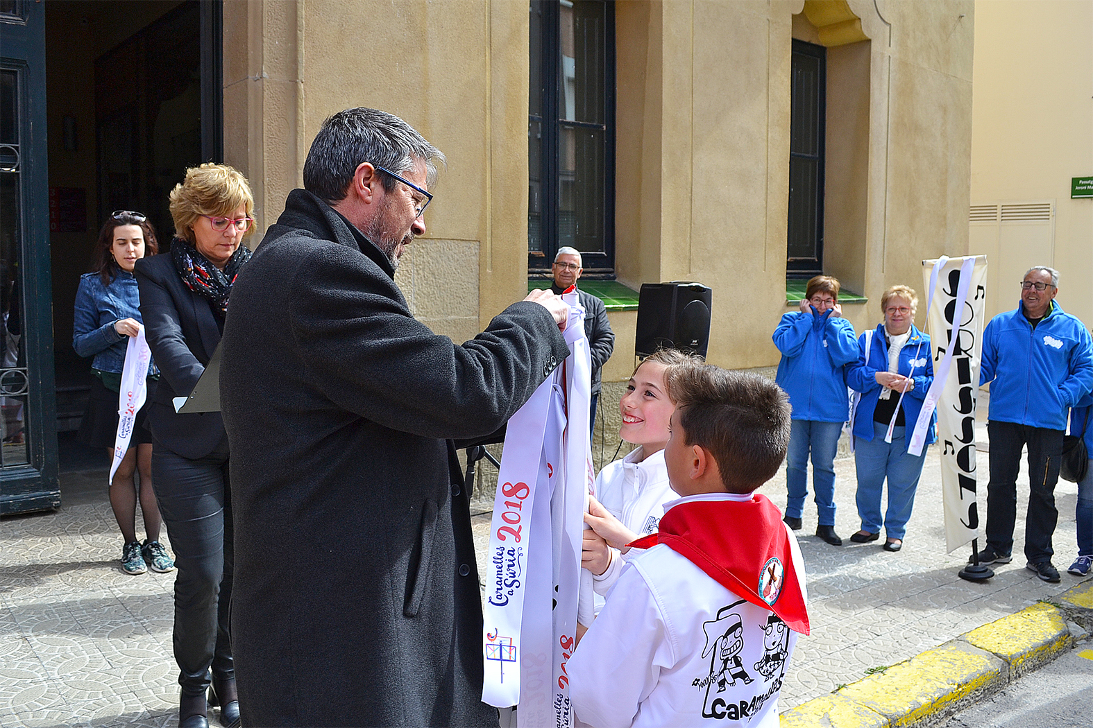L'alcalde Josep Maria Canudas posa la cinta de les Caramelles de SÃºria 2018 a l'estendard de la colla dels Petits de l'AgrupaciÃ³ Sardanista - MarÃ§ de 2018.
