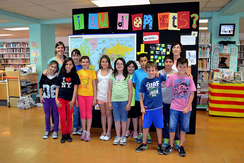 Curs 2013-14 - Membres del Consell Municipal dels Infants, la regidora de Benestar Social, Carme Besa, i la tÃ¨cnica de l'Ã rea de Benestar Social, amb el plafÃ³ que resumeix el treball realitzat durant el curs, a la Biblioteca PÃºblica.