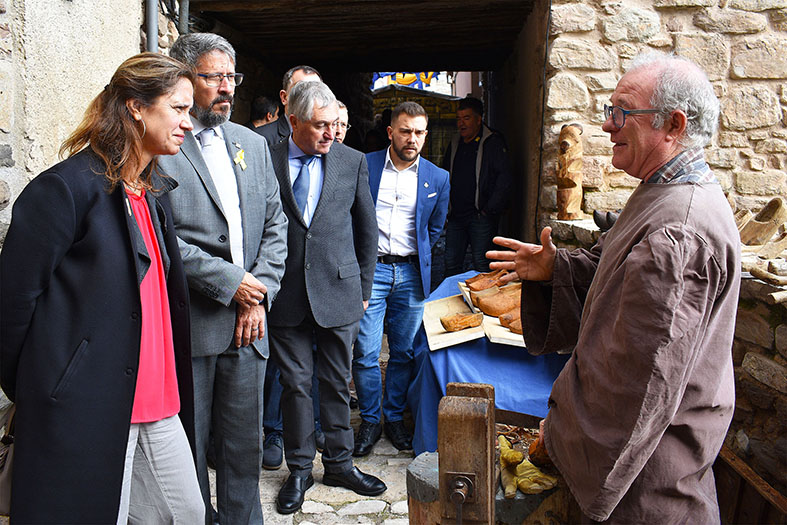 Un artesÃ  parla amb la directora general de Turisme de la Generalitat, Muntsa Vilalta, i lâ€™alcalde Josep Maria Canudas, durant la visita dâ€™autoritats a la 17a Fira Medieval dâ€™Oficis de SÃºria - Novembre de 2018.