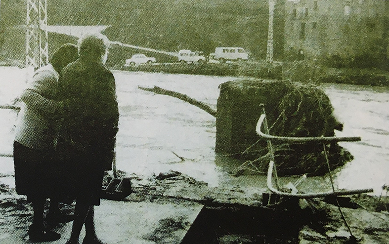Any 1982 - Dues persones miren les restes de l'antiga palanca del barri de Salipota, destrossada per la riuada del mes d'octubre (font: llibre 'Salipota, SÃºria. El barri que va nÃ©ixer dues vegades' de Roger HernÃ¡ndez).