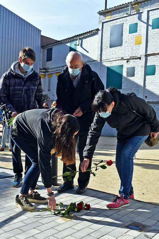 Familiars fan l'ofrena floral sobre la llamborda Stolpersteine de Manuel Fernández López.