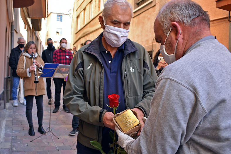 Un familiar lliura la llamborda Stolpersteine de Climent Girona Prades.