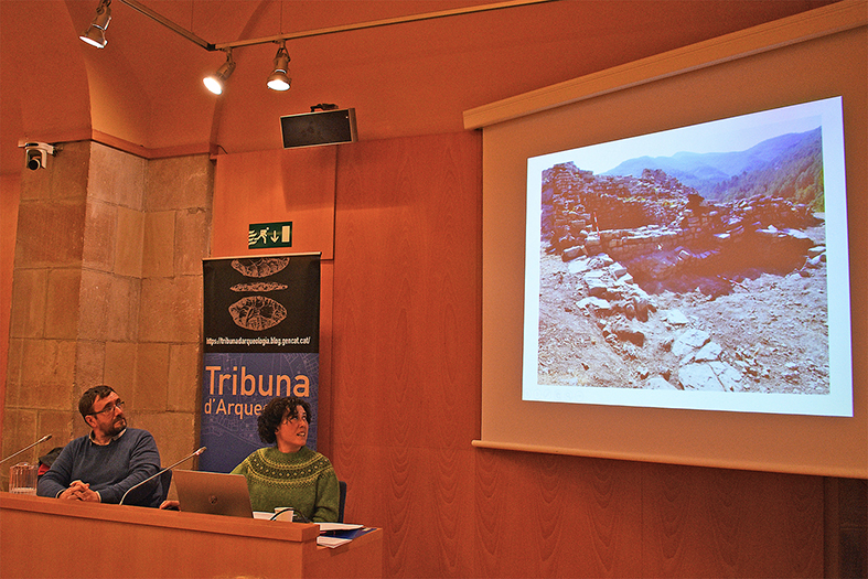 Imatge de la conferència celebrada a la Tribuna d'Arqueologia de la Generalitat sobre la Campanya d'Excavacions Arqueològiques a les Guixeres, amb l'arqueòloga Cristina Belmonte i el presentador de l'acte, Josep Maria Vila.