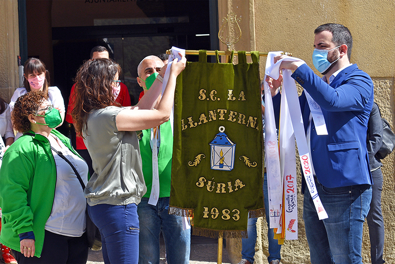 Colâ€¢locaciÃ³ de les cintes commemoratives dels anys 2020 i 2021 a lâ€™estendard de la colla de La Llanterna, durant lâ€™acte dâ€™obertura de les Caramelles de SÃºria, al davant de la Casa de la Vila.