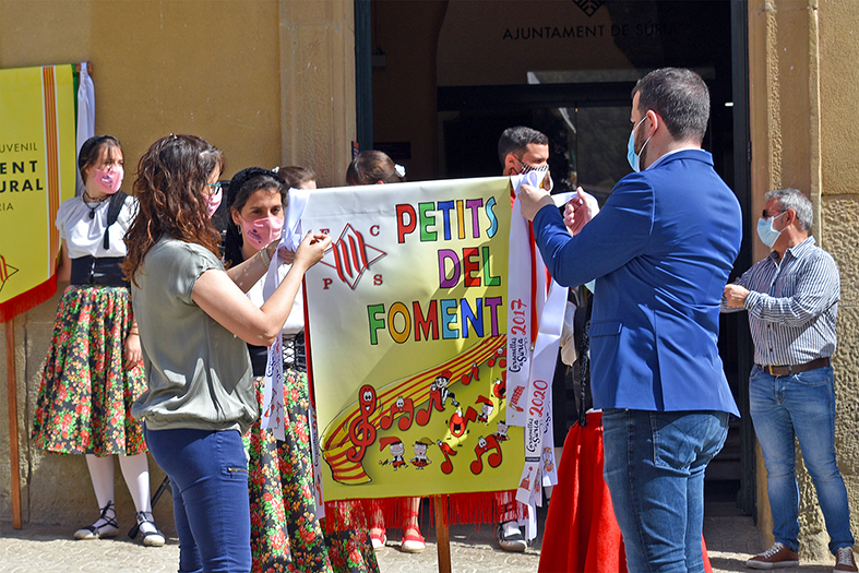 Colâ€¢locaciÃ³ de les cintes commemoratives dels anys 2020 i 2021 a lâ€™estendard de la colla Infantil del Foment Cultural, durant lâ€™acte dâ€™obertura de les Caramelles de SÃºria, al davant de la Casa de la Vila.