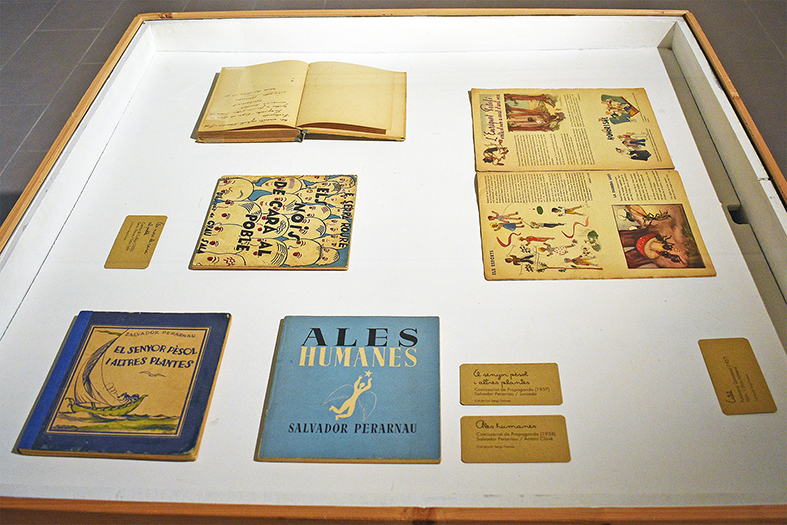 Any 2021 - Vitrina de lâ€™exposiciÃ³ 'Contes infantils de la Guerraâ€™ a la sala Cal Balaguer del Porxo, amb diferents llibres i documents del poeta surienc Salvador Perarnau.