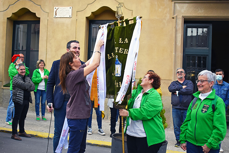 La regidora de Festes, Alba Santamaria, posa la cinta commemorativa de les Caramelles dâ€™enguany a lâ€™estendard de la colla de La Llanterna, durant lâ€™acte dâ€™inici de la festa.