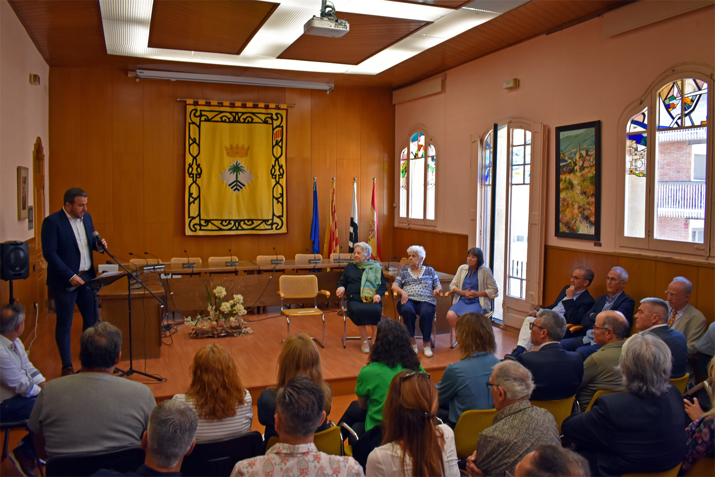 L'alcalde Albert Coberó parla durant l'acte institucional en record de l'alcalde Florenci Claret al saló de sessions de la Casa de la Vila, al costat dels familiars. 