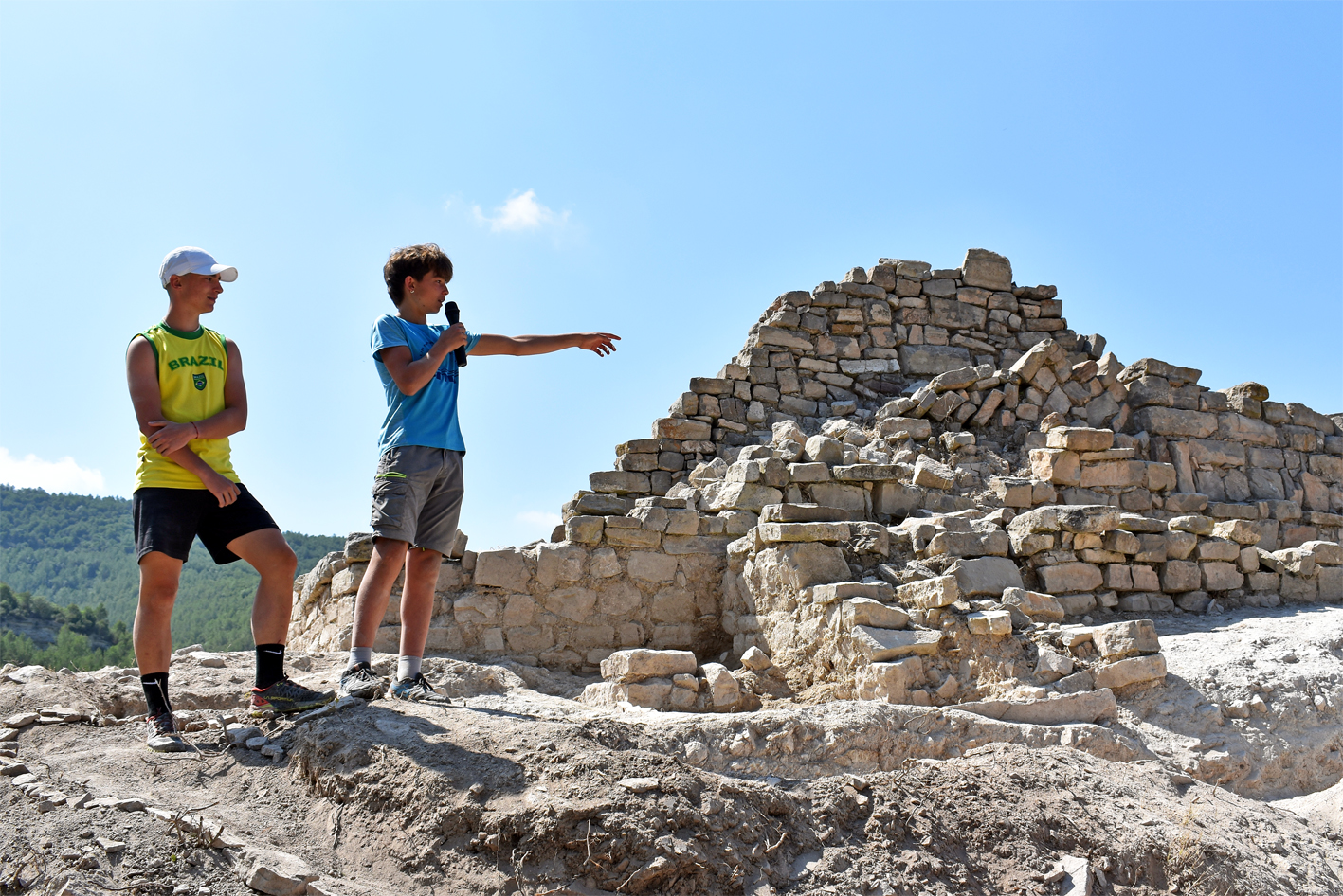 Alumnes de l'Institut Mig-M&oacute;n expliquen les troballes de la 18a Campanya d'Excavacions Arqueol&ograve;giques, durant la visita de cloenda d'aquesta edici&oacute;, a l'Espai Patrimonial de les Guixeres.